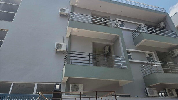A multi-story building with balconies, air conditioning units, and a blue roof. - Classic Pine Villa (Lucknow)
