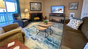 Ein Wohnzimmer mit Kamin, Fernseher und einer Couch.