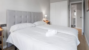 A bedroom with a large bed, a bedside table, a lamp, and a wardrobe. - 6-guest Haven Near Golden Mile (Madrid)