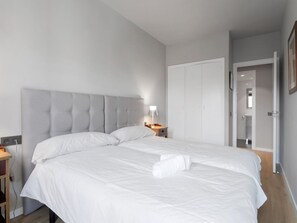 A bedroom with a large bed, a bedside table, a lamp, and a wardrobe. - 6-guest Haven Near Golden Mile (Madrid)