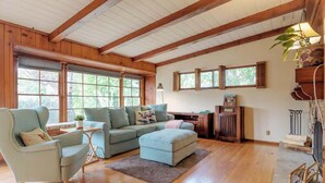 A spacious living room with wooden beams, a sectional sofa, a small armchair, and a wooden cabinet. - 109 GATED Urban LA cottage (Los Angeles)