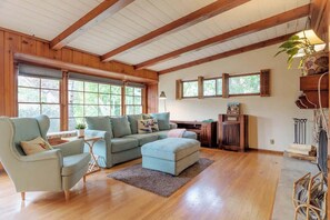 A spacious living room with wooden beams, a sectional sofa, a small armchair, and a wooden cabinet. - 109 GATED Urban LA cottage (Los Angeles)