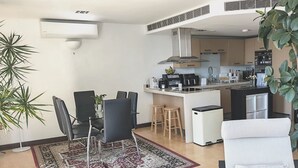 Une cuisine moderne dotée d’un îlot central, d’un coin repas avec des chaises et d’un petit réfrigérateur.