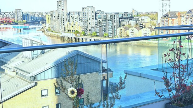 Un immeuble de grande hauteur offrant une vue sur une rivière et le paysage urbain.