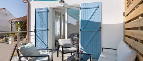 An outdoor seating area with a table, chairs, and a blue awning.