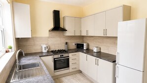 Una cocina moderna equipada con estufa, horno, microondas y refrigerador.