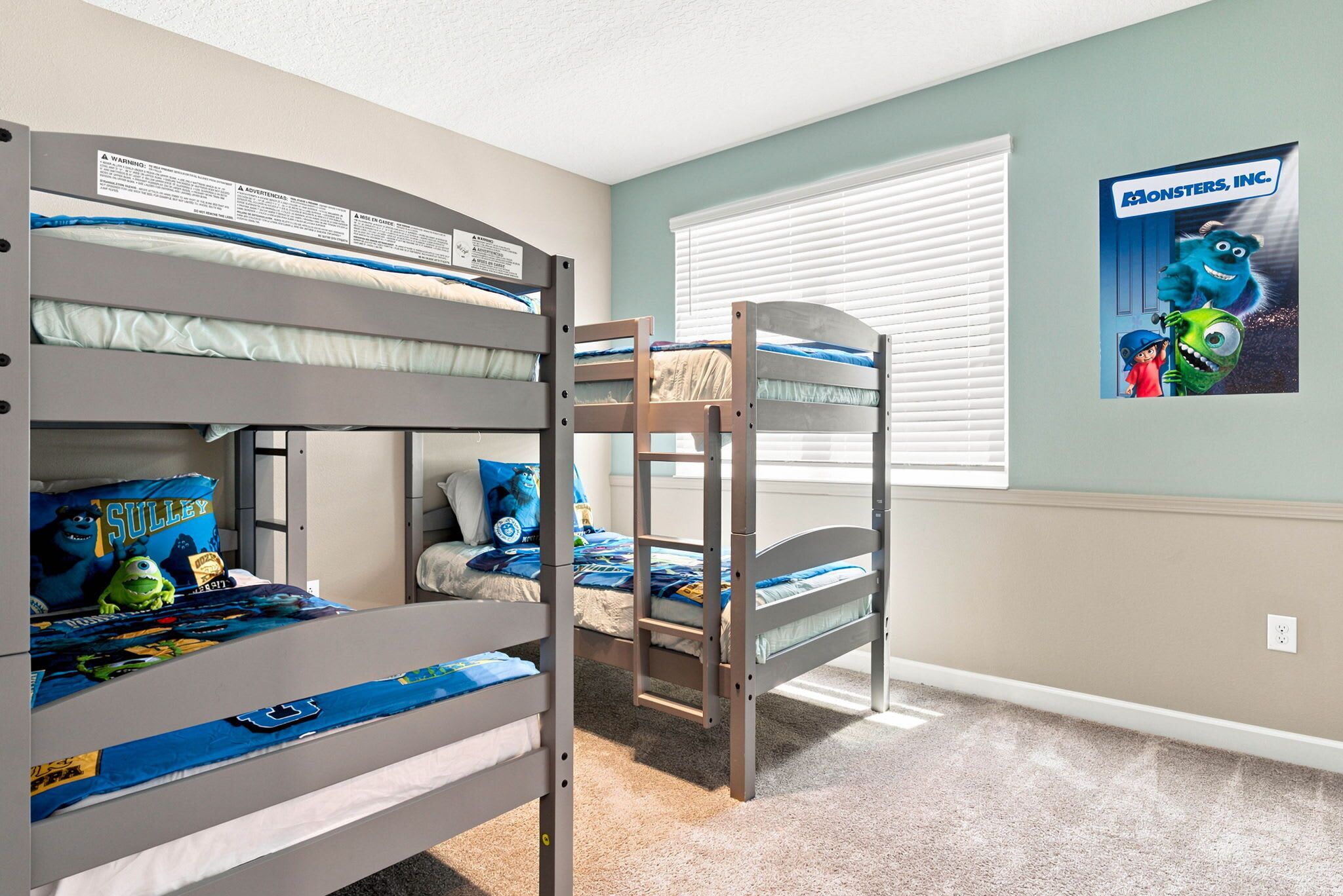 Camera con letto a castello e un poster di Monsters, Inc.