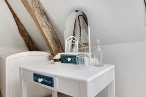 A white bedside table with a mirror, a small white chair, a decorative hanging, and a bottle. - Guest Room “Large Space, 2 Bedrooms, Private Bathroom” with Wi-Fi and Air Conditioning (Hommes)