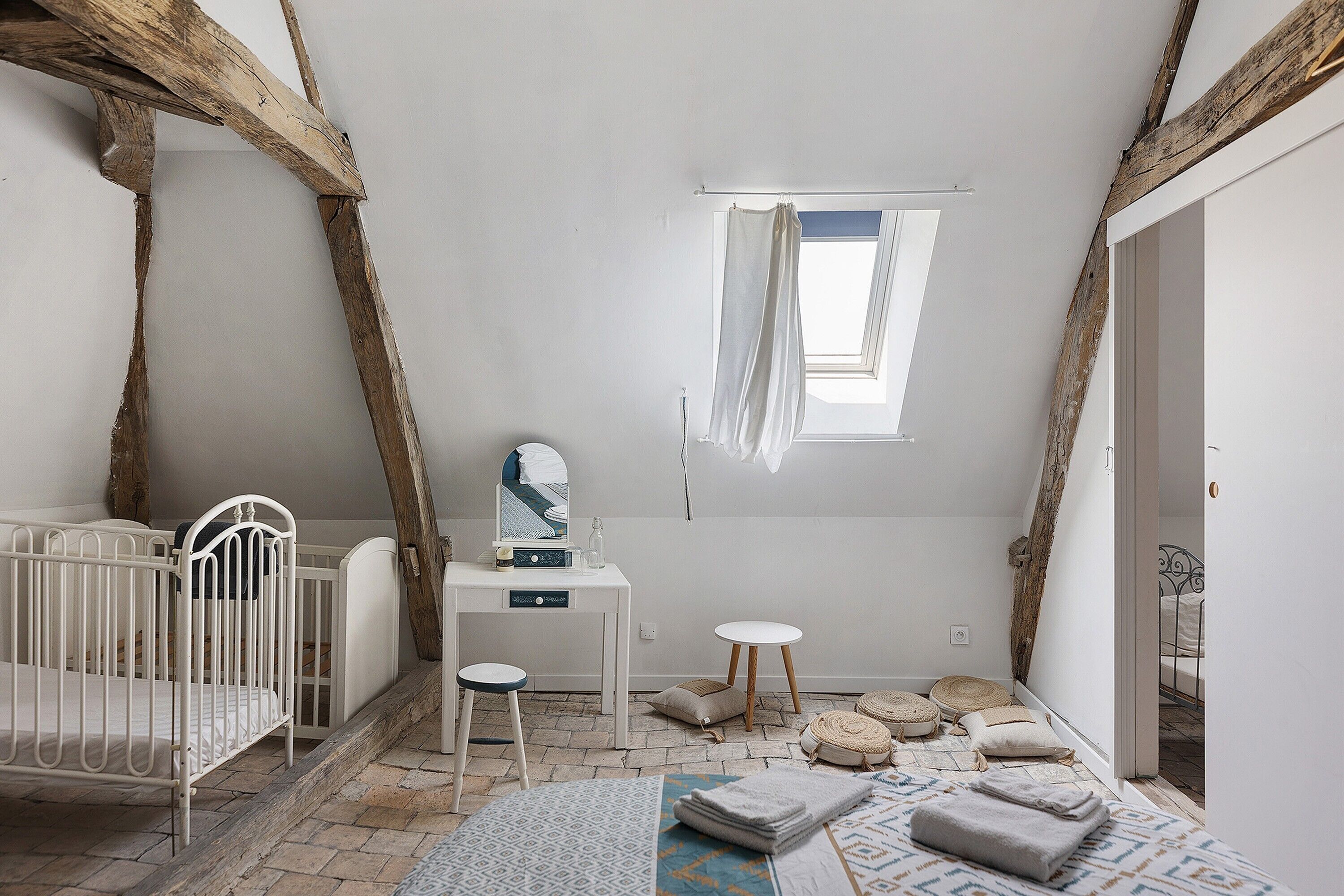 Een kinderkamer met een ledikant, een bureau en een raam.