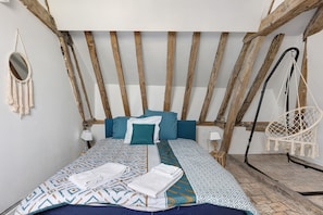A bed with patterned bedding, a macrame wall hanging, and a hanging chair. - Guest Room “Large Space, 2 Bedrooms, Private Bathroom” with Wi-Fi and Air Conditioning (Hommes)
