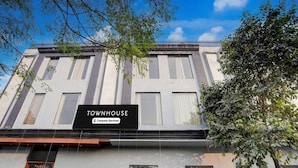Um edifício de vários andares com uma placa indicando 'TOWNHOUSE' e a etiqueta 'Company-Serviced'.