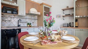 Une cuisine moderne avec une table à manger dressée pour le repas, équipée d’un lave-vaisselle, d’un four à micro-ondes et de divers appareils de cuisine.
