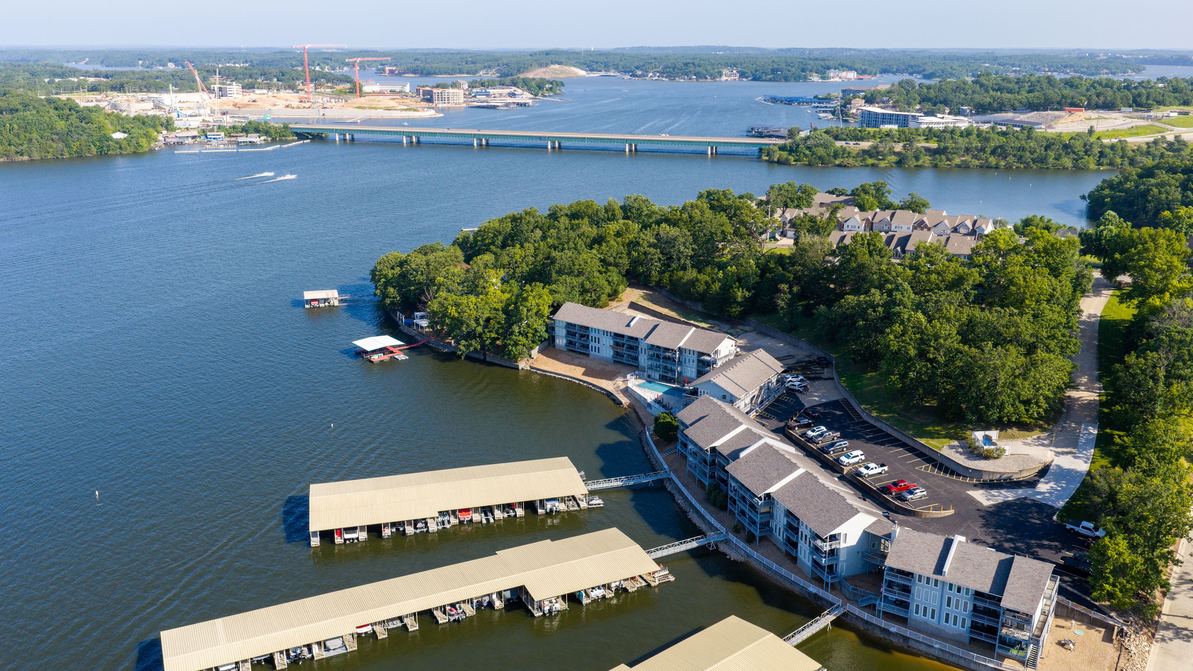 Eine Luftaufnahme eines Anwesens am Wasser mit einem Hafen, Gebäuden und einer Brücke im Hintergrund.