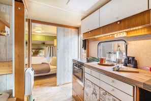 A compact kitchenette with a stove, oven, and a small sink. - Tiny Home with Private Terrace on the Mönchgut Peninsula (Mönchgut)
