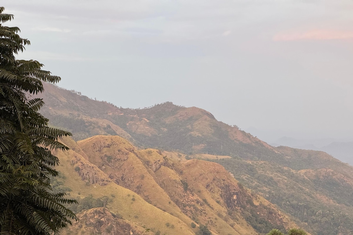 A mountainous landscape with rolling hills and sparse vegetation.