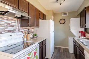 A modern kitchen with a stove, refrigerator, and cabinets. - Tranquil Oasis Retreat. (Sierra Vista)