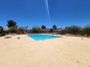 A backyard with a swimming pool, picnic tables, and a fenced area. - Tranquil Oasis Retreat. (Sierra Vista)