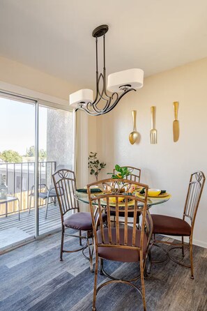 A dining area with a round table, chairs, and a chandelier. - Tranquil Oasis Retreat. (Sierra Vista)