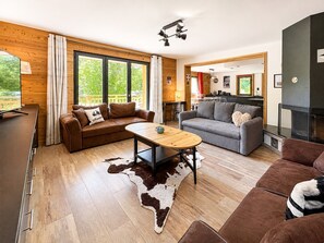 Ein modernes Wohnzimmer mit einer Couch, einem Couchtisch und einem Kamin.