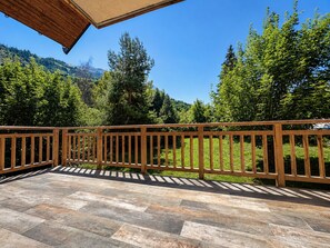 A wooden deck with a view of a forest and mountains. - Apartment - Le Batchu - Valloire - 12 guests (Valloire)