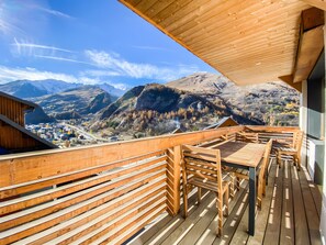 A wooden deck with a table and chairs, overlooking a mountainous landscape. - Apartment - Le Chaniski - Valloire - 4 guests (Valloire)