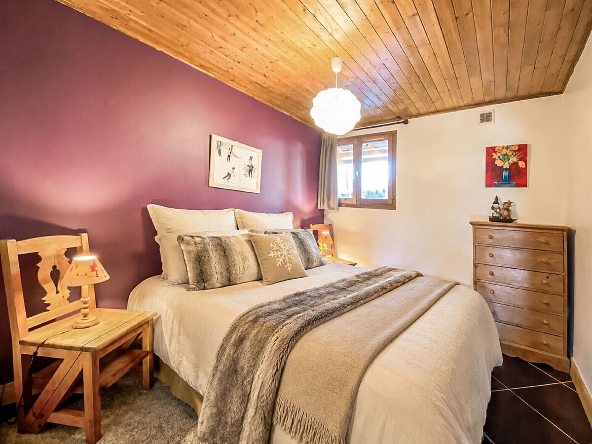 Un dormitorio con cama, cabecera de madera, mesita de noche, lámpara, cómoda y ventilador de techo.