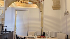 A dining area with a round table, chairs, and a hanging light fixture. - Angel Apartment 1 - Two Bedroom Apartment, Sleeps 4 (Monopoli)