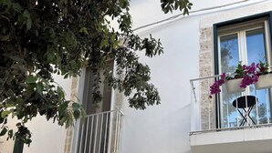A building with a balcony, a door with a glass panel, and a window with a view. - Angel Apartment 1 - Two Bedroom Apartment, Sleeps 4 (Monopoli)
