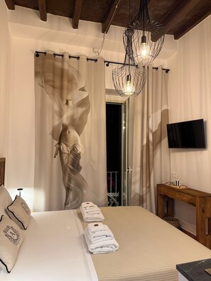 A bedroom with a bed, a flat-screen TV, a wooden bedside table, and a decorative wall piece. - Angel Apartment 2 - One Bedroom Apartment, Sleeps 2 (Monopoli)