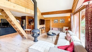 A wooden interior with a sofa, a fireplace, and a staircase. - Chalet Alpenroc - Valloire (Valloire)