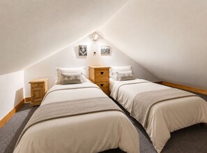 A bedroom with two beds, a wooden nightstand, and a dresser. - Chalet Alpenroc - Valloire (Valloire)