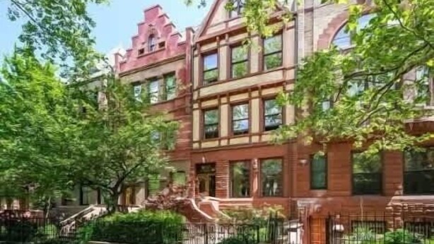 A multi-story building with a brick facade, large windows, and a prominent entrance.