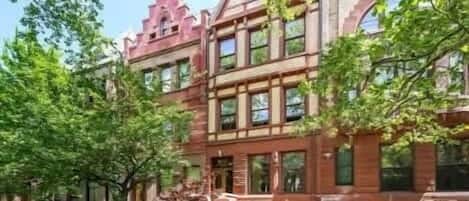 A multi-story building with a brick facade, large windows, and a prominent entrance.