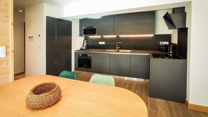 Een moderne keuken met donkere kastjes, een inbouwoven en een magnetron.