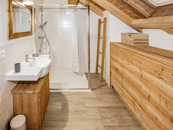 A modern bathroom with a wooden vanity, a glass shower enclosure, and a wooden ladder. - Chalet Le Pure Altitude Valloire (Valloire)