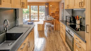 Una cocina moderna con armarios de madera, electrodomésticos de acero inoxidable y un comedor con vistas.