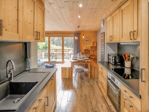Eine moderne Küche mit Holzschränken, Edelstahlgeräten und einem Essbereich mit Blick.