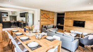 Um espaço moderno para relaxar, com área de jantar, cozinha e espaço para sentar.