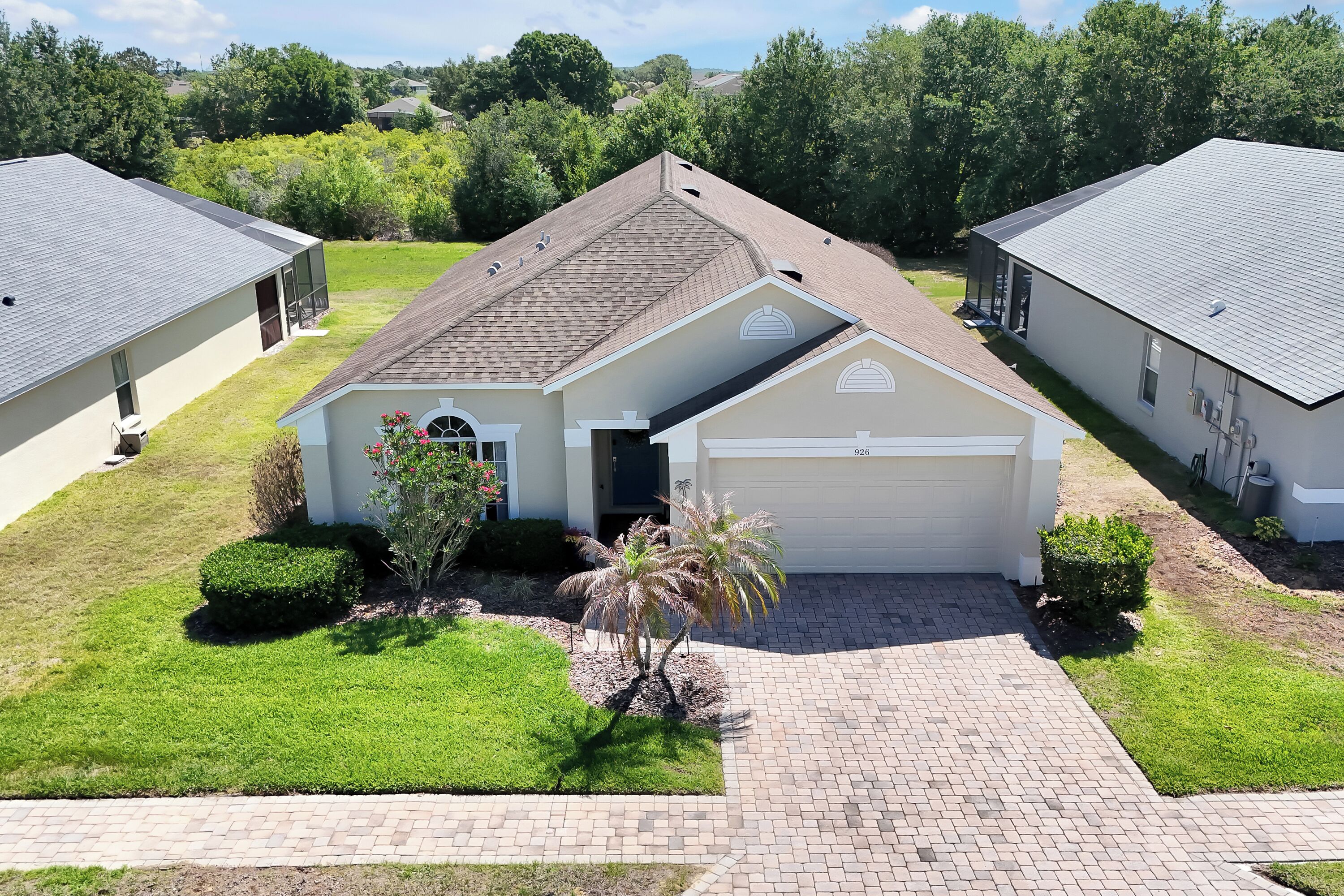 A residential house with a garage, a driveway, and a well-maintained lawn.