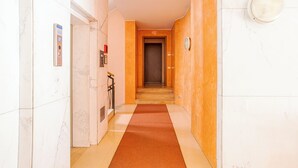 A hallway with a marble floor, a red carpet, and a door at the end. - Franklin's House Como, Como, Italy (Como)