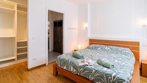 A bedroom with a bed, a wooden headboard, a bedside table, a nightstand, and a wardrobe. - Franklin's House Como, Como, Italy (Como)