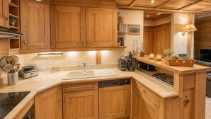 A wooden kitchen with a dishwasher, a sink, and a stove. - Apartment - Le Pti Chalet Valloire - 6 People (Valloire)