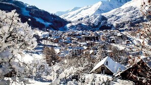 A snow-covered village with traditional buildings, mountains in the background, and a clear sky. - Apartment - Le Pti Chalet Valloire - 6 People (Valloire)