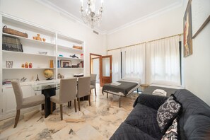 A hotel room with a dining area, a sofa, a bed, and a large window with curtains. - Apartment 'Wellhome Sevilla Centro' with Wi-Fi, parking (€20) and air conditioning (Seville)