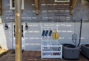 An outdoor area with a white metal fence, a wooden post, and two air conditioning units. - Longtail Cottage (Nantucket)
