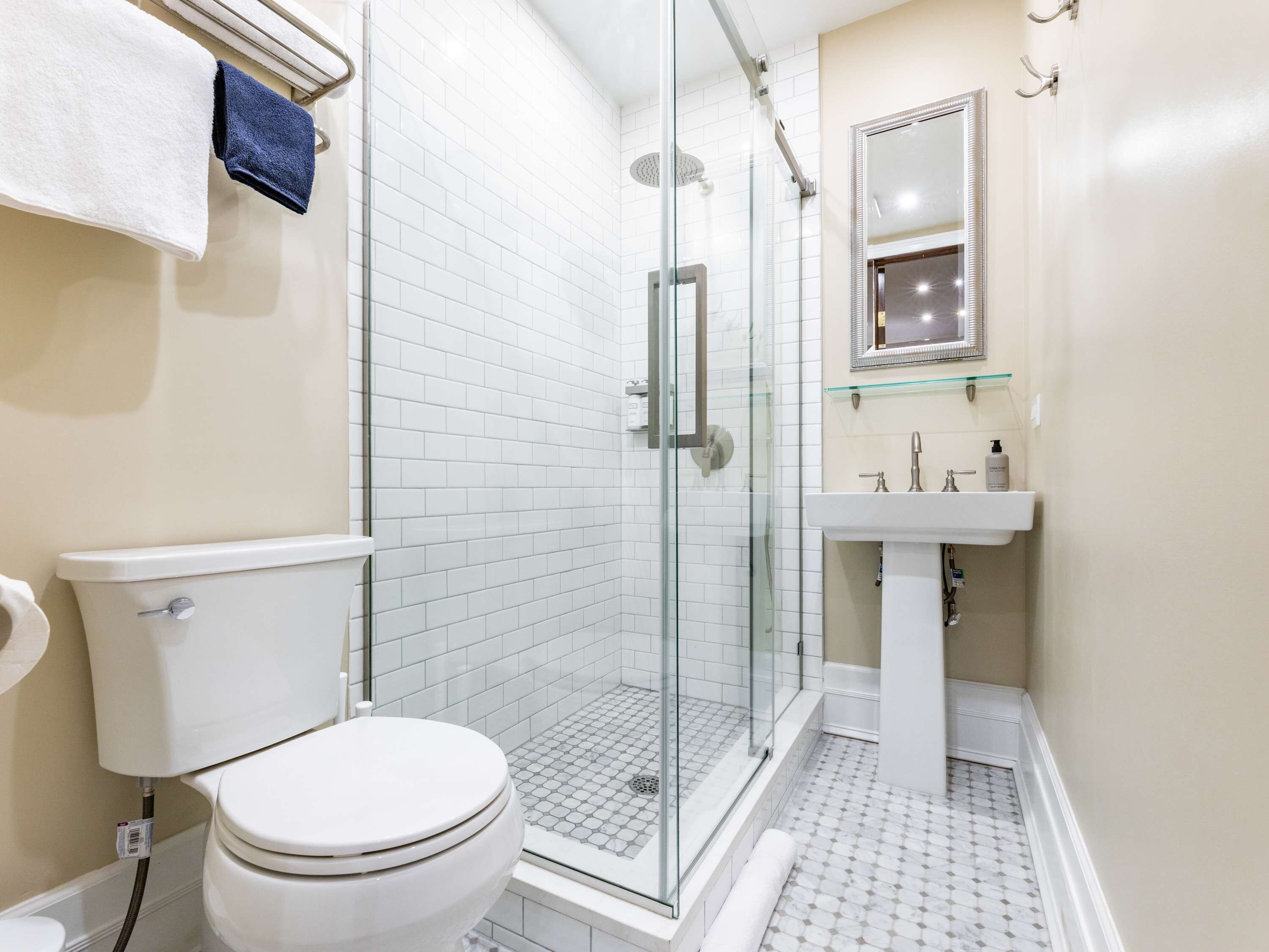 A bathroom with a toilet, a glass-enclosed shower, and a sink.