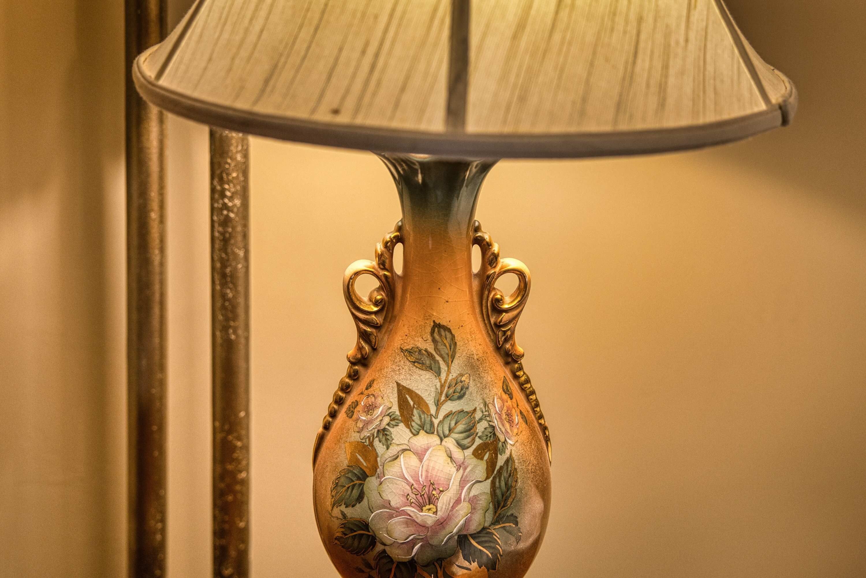 Een bureaulamp met een bloemmotief op de voet.