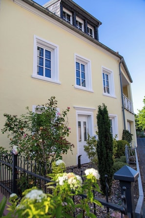 A two-story building with a yellow facade, white trim, and multiple windows.
