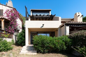 A modern building with a flat roof, a balcony with a railing, and a clear blue sky. - Casa di Palombaggia - Appt avec belle vue mer (Porto-Vecchio)