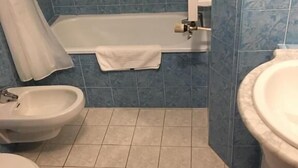 A bathroom with a bathtub, a bidet, a toilet, and a sink. - Hotel Val Du Tech  (Prats-de-Mollo-la-Preste)